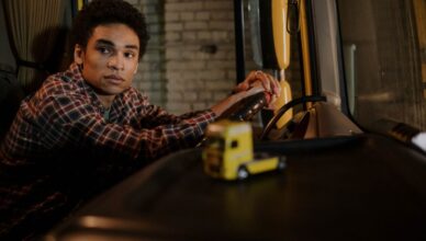Chauffeur met rijbewijs C achter het stuur van een vrachtwagen op de weg, symboliseert carrièremogelijkheden in transport.